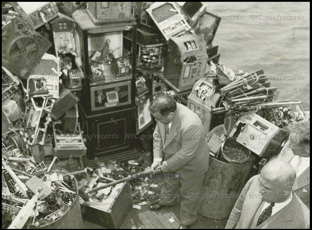 Mayor LaGuardia smashes a slot machine, as part of his attempt to destroy the slot machine racket, 1934. 